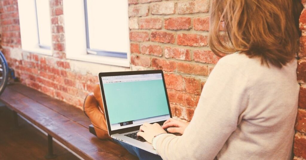 The EU Whistleblowing Directive: Woman typing on a laptop.